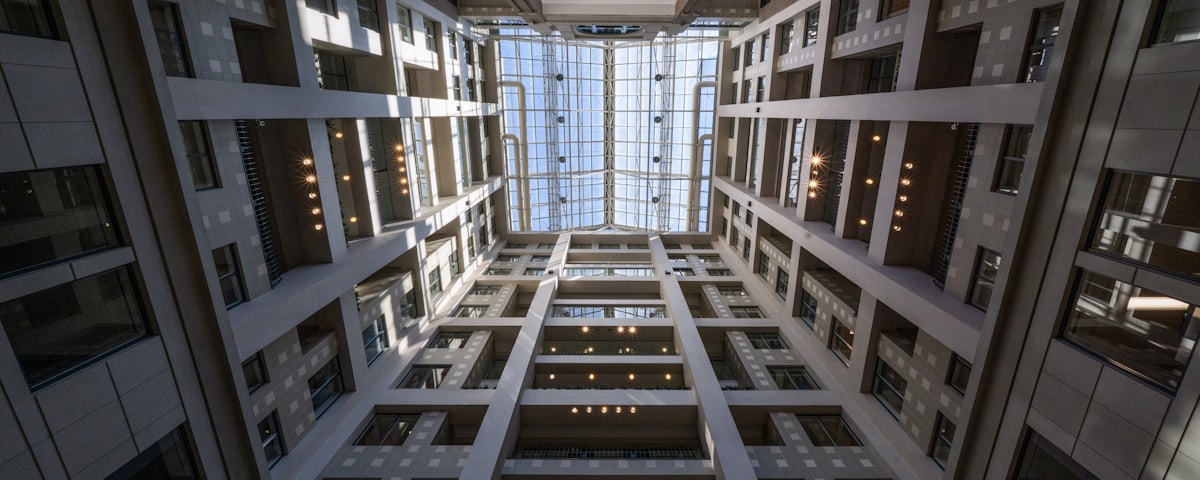 A symmetrical office atrium rising toward a glass skylight